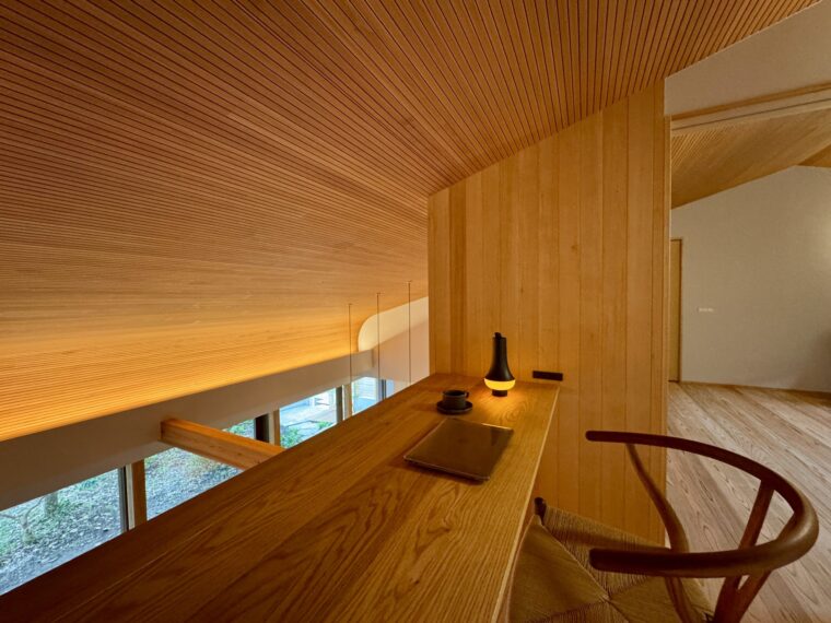 二階のフリースペースから吹き抜けを臨む。天井には桧のリブ加工した羽目板張り。障子を仕込んだオークの造作家具