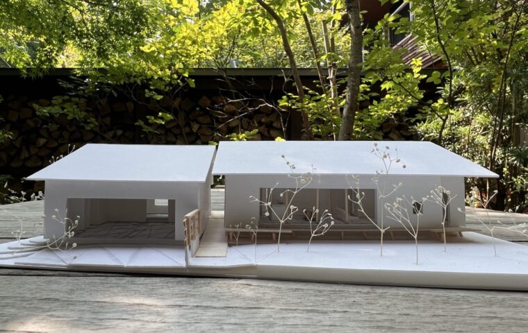 二棟が連なる平屋ベースの外観。天龍の杉板を素地のまま縦張りした外壁と既存庭に雑木を付加して整えた外構も見所<br />
約6mの大開口シャッターのある離れの脇からバリアフリーのデッキスロープ玄関までアプローチを可能にしました。